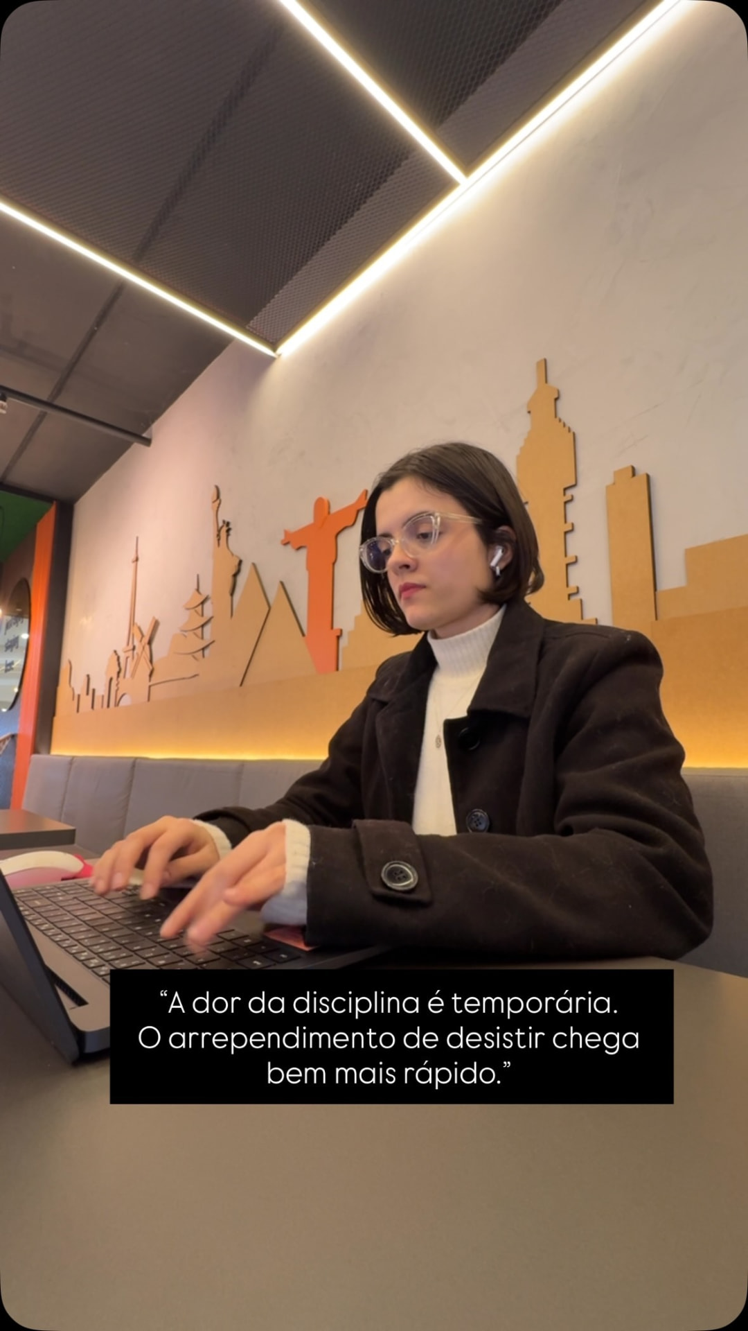 Laura trabalhando em notebook em ambiente profissional
